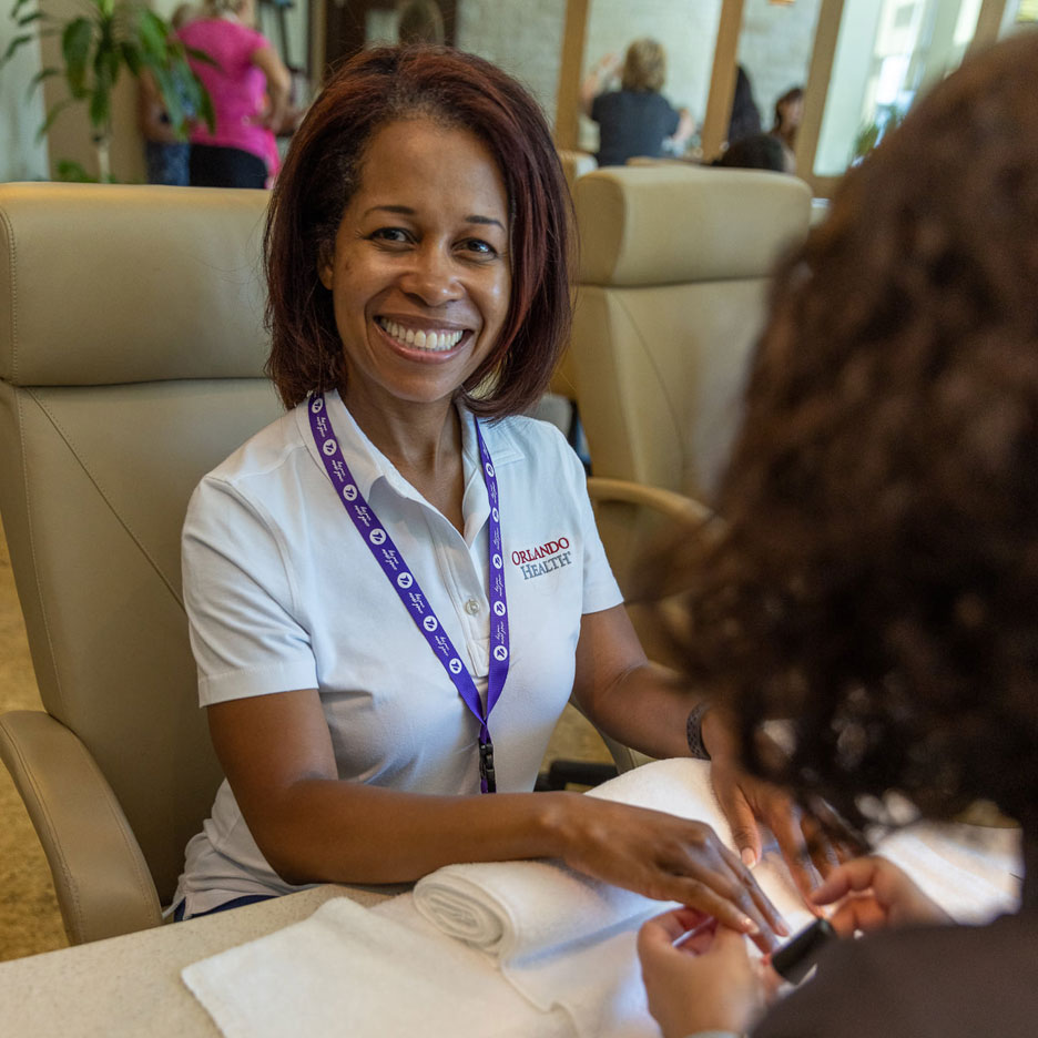 Woman smiling at the camera while having her nails done